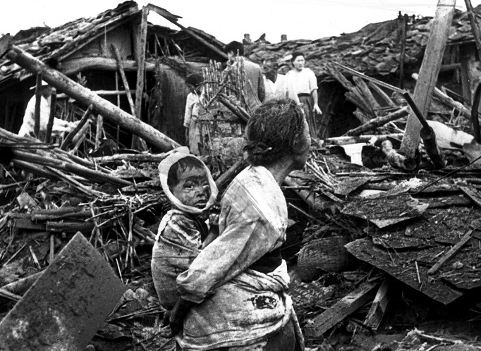   An elderly woman and her grandchild wander among the debris of their wrecked home in the aftermath of an air raid by U.S. planes over Pyongyang, the Communist capital of North Korea, circa 1950.  Photo: Keystone/Getty Images